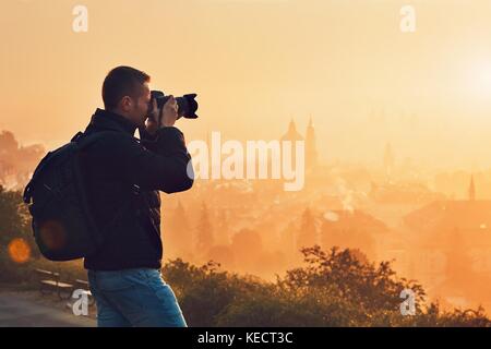 Photographe à l'aube. Jeune homme prendre photo de la ville. Prague, République tchèque. Banque D'Images