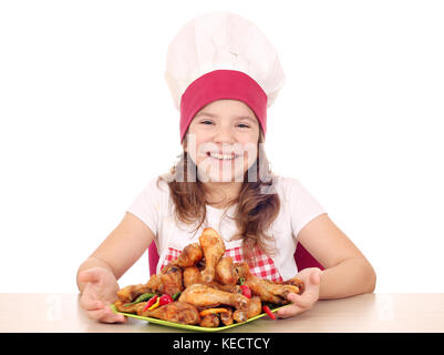 Happy little girl cook avec pilons de poulet grillés sur la plaque Banque D'Images