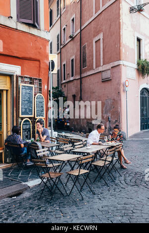 Amis partager un aperitivo (apéritif) à des tables dans un café à Rome, Italie Banque D'Images