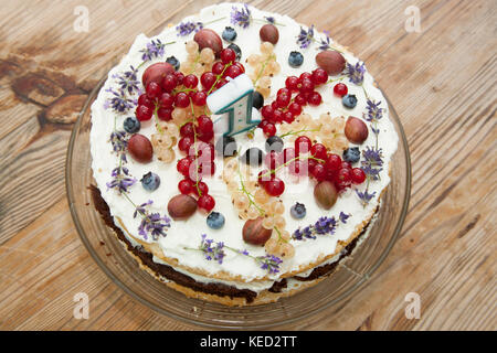 Fruité gâteau d'anniversaire en bonne santé avec un certain nombre de bougies sur table en bois 1 Banque D'Images