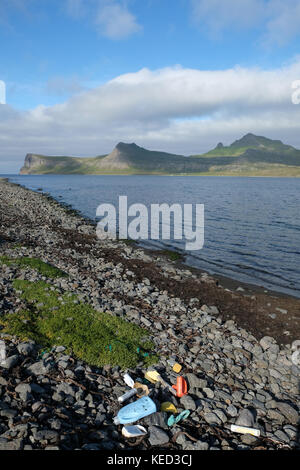 Déchets de déchets de déchets sur la plage déserte et danger pour l'environnement avec le fjord et les montagnes, réserve naturelle de Hornstrandir, près d'Isafjordur, Westfjords, Islande Banque D'Images