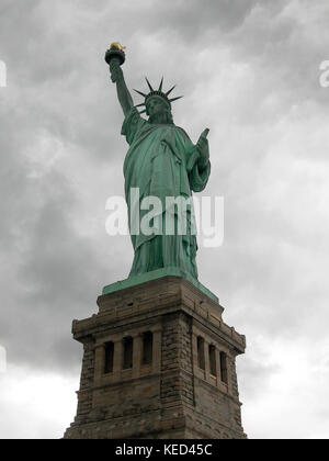 Statue de la liberté vu de l'avant avec un ciel nuageux et gris comme arrière-plan de Manhattan, à New York. Banque D'Images