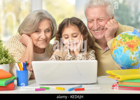 Les grands-parents et little girl using laptop Banque D'Images