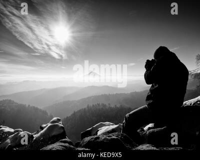 Homme de grande taille est de prendre en photo l'appareil photo miroir sur le cou. snowy piton rocheux de montagne. photographe professionnel prend des photos avec l'appareil photo sur le pic de miroir Banque D'Images