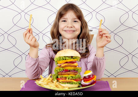 Little girl with big hamburger et frites Banque D'Images