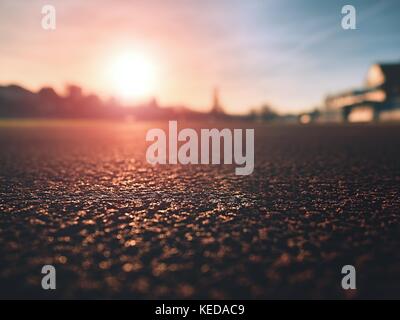 Plus d'une piste de course à un stade sportif. close up red racetrack la masse sur le stade en plein air. Les rayons du soleil. Le sport et un mode de vie sain, la formation concept Banque D'Images