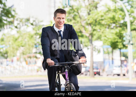 Portrait of happy young woman riding bicycle Banque D'Images