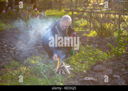 Man de faire un feu dans le jardin Banque D'Images