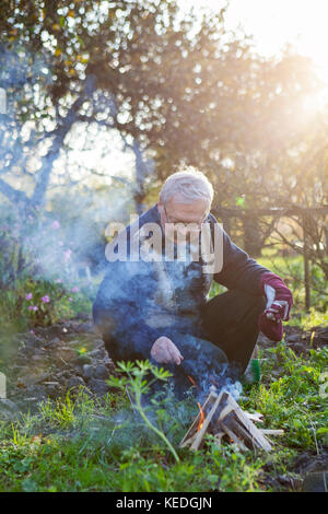 Man de faire un feu dans le jardin Banque D'Images