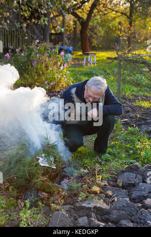 Man de faire un feu dans le jardin Banque D'Images