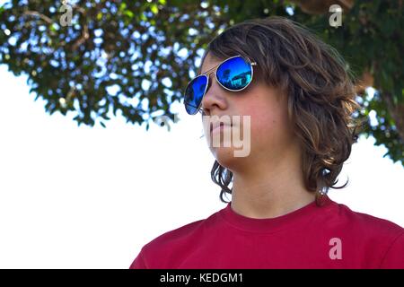 Les jeunes mâles adolescents portant des lunettes bleu head shot contre l'arrière-plan de banlieue. Banque D'Images