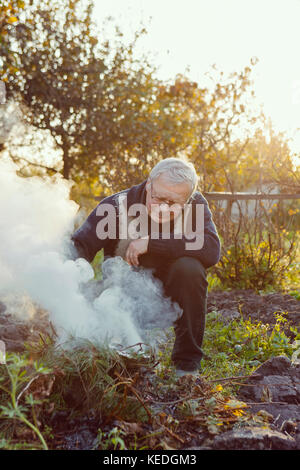 Man de faire un feu dans le jardin Banque D'Images