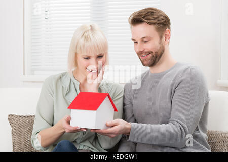 Young happy couple holding une maison modèle, Banque D'Images