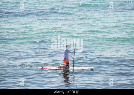 Stand Up Paddle boarder agenouillée paddle Banque D'Images