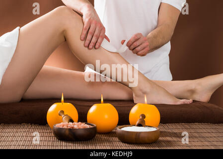 Close-up of a Woman Getting sa jambe par l'application de bandes de cire ciré Beauty Spa Banque D'Images