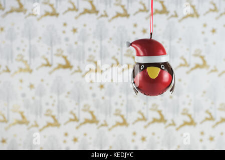 Photographie image de Noël de Noël la décoration de raccrocher de red robin avec chapeau de noël avec gold glitter background papier cadeaux de noël renne Banque D'Images