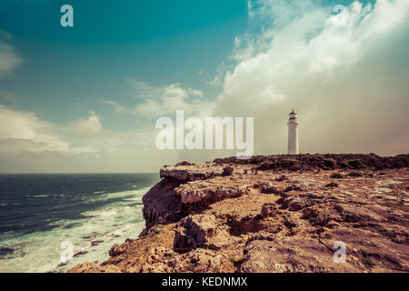 Cape nelson lighthouse debout sur une falaise au-dessus des océans sous un ciel orageux. Victoria, Australie. image a rétro pour elle Banque D'Images