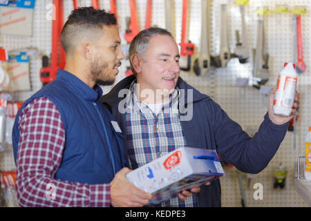 Les hommes du choix d'un produit dans un magasin Banque D'Images