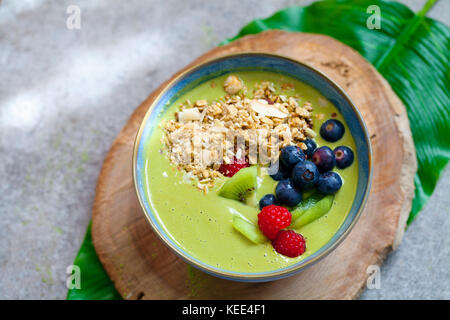 Smoothie matcha vert avec des bleuets, framboises et kiwis Banque D'Images