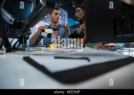 Les ingénieurs en informatique réparation carte mère at desk in office Banque D'Images