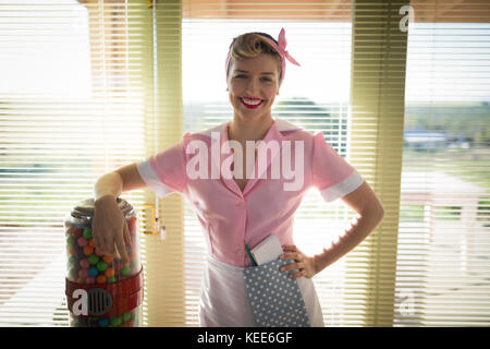 Young waitress standing with hand on hip in restaurant Banque D'Images