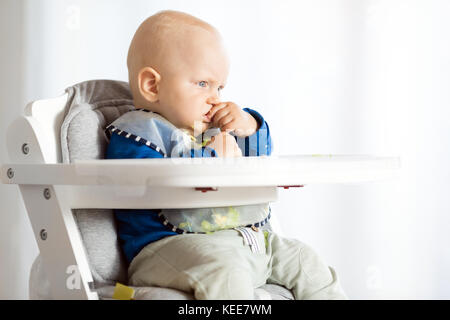 Baby Boy eating bread et concombre avec méthode, BLW led bébé sevrage. Kid végétarien grave au dîner. Manger de l'enfant lui-même, auto-alimentent. Banque D'Images