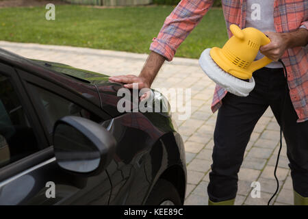 Service de nettoyage automatique du personnel masculin une voiture avec brosse de lavage rotative Banque D'Images