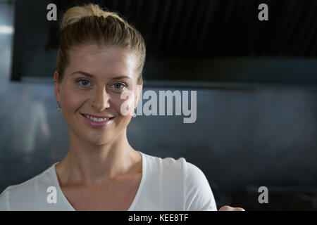 Portrait de femme chef debout dans la cuisine Banque D'Images