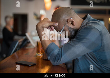 Homme debout appuyée au comptoir de bar Banque D'Images