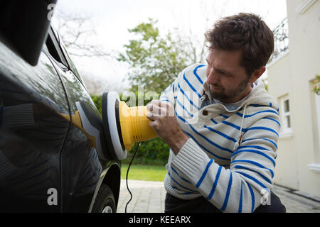 Service de nettoyage automatique du personnel masculin une voiture avec brosse de lavage rotative Banque D'Images