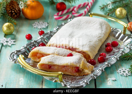 Strudel aux pommes fait maison avec des pommes fraîches, de canneberge et de sucre en poudre sur l'ardoise ou de pierre arrière-plan. Banque D'Images