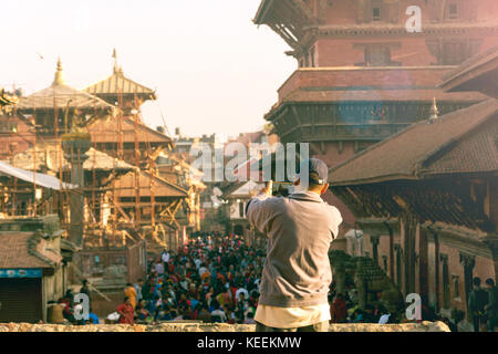 Un inconnu prenant une photo de la foule à Patan Durbar Square par son téléphone intelligent Banque D'Images