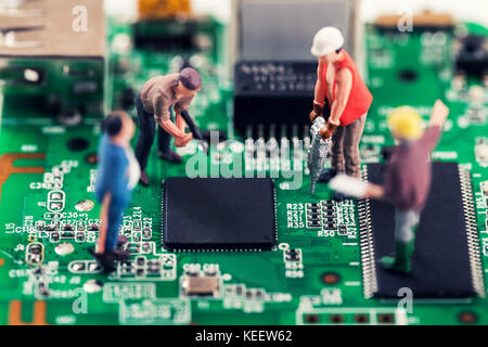 Réparation de l'électronique et le support technique concept - les travailleurs de la réparation de circuit imprimé Banque D'Images