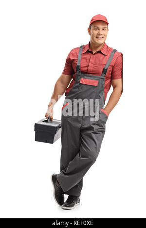 Portrait d'un réparateur tenant une boîte à outils et appuyé contre un mur isolé sur fond blanc Banque D'Images
