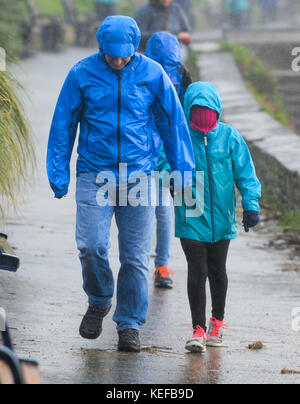 Swansea, Pays de Galles, Royaume-Uni. 21 oct, 2017. uk weather. Une famille font leur chemin à travers la pluie et vent fort à la baie de langland, Gower, Swansea, comme Brian storm hits la partie ouest du Royaume-Uni, portant des coups de vent et de fortes pluies. © Robert melen/Alamy live news Banque D'Images