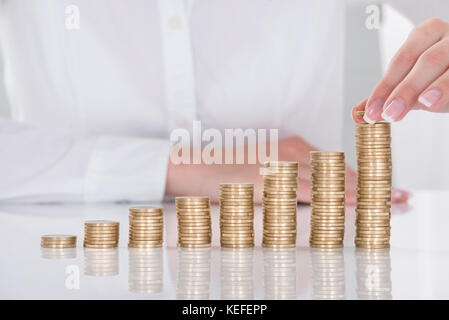 Close-up of Businesswoman main mise sur pile de pièces de monnaie à 24 Banque D'Images