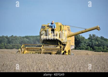 Cabine ouverte ancienne moissonneuse-batteuse new holland jaune de la récolte de cultures d'une exploitation agricole en 2017 Banque D'Images
