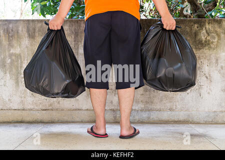 La section basse d'un jeune homme portant des sacs à Banque D'Images