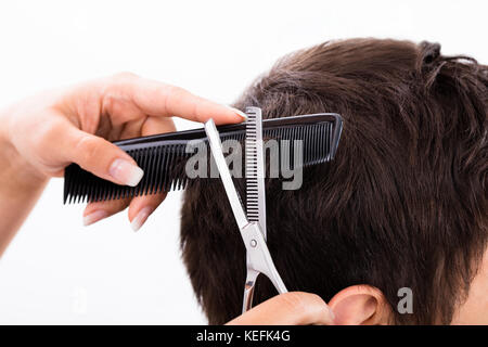 Close-up d'une personne qui coupe de coiffure à salon Banque D'Images