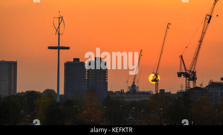 Magnifique coucher de soleil orange derrière des grues de construction dans la zone de régénération de Stratford, parc olympique Queen Elizabeth, est de Londres, Royaume-Uni Banque D'Images