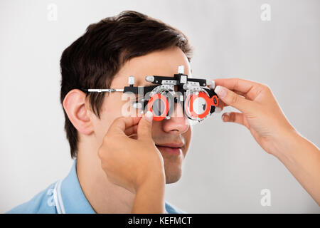 Close-up d'un optométriste contrôle Male Patient Vision avec le cadre à l'essai clinique Banque D'Images
