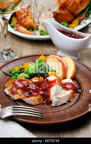 Tranches de dinde cuite au four avec sauce aux canneberges et à l'orange avec la garniture de légumes et fruits Banque D'Images