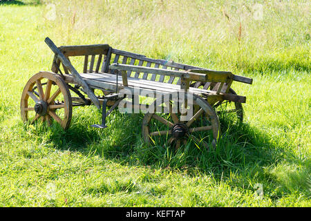 Rural ancien wagon vide en bois se dresse sur l'herbe d'été vert Banque D'Images