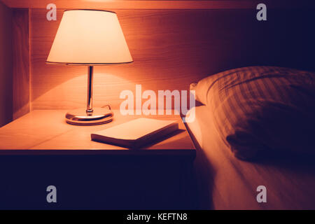 Livre à table de nuit dans la chambre à coucher, selective focus Banque D'Images