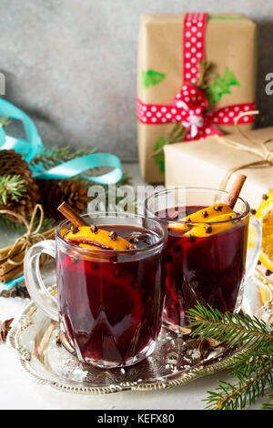 Cocktail de noël fait maison du vin Le vin rouge avec des bâtons de cannelle, d'oranges et de girofle, servi dans deux tasses sur une pierre ou gris ardoise. copier l'espace. Banque D'Images