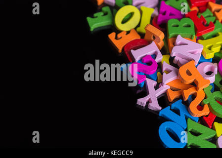 Beaucoup de lettres de couleur sur fond noir en plastique. Banque D'Images