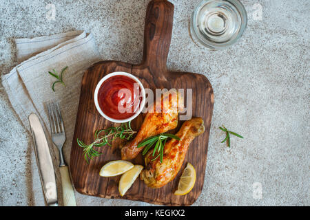 Pilons de poulet épicé grillé est servi sur une planche de bois. Top View with copy space Banque D'Images