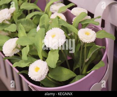 Jolies fleurs artificielles blanc avec des feuilles vertes en pot de fleur pour la décoration de maison et de bureau sans l'attention. Banque D'Images