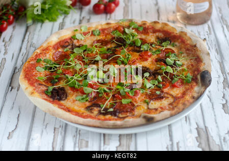 Pizza au pepperoni, surmontées de cress Banque D'Images