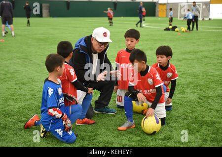 Commentateur de football chinois Dong Lu 'coaching' sous les garçons Football Chine 9 5 football équipe sur leur tournée au Royaume-Uni Banque D'Images